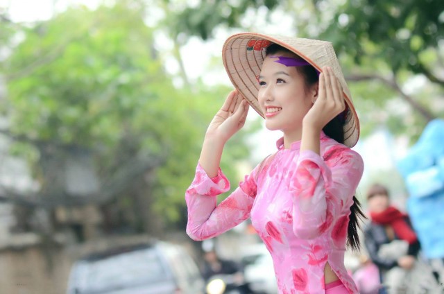 ピンクのアオザイを着ているベトナム人女性